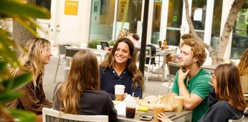 Five students gather at an outdoor table in Scott Courtyard